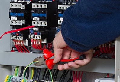 electrician at work with an alectric panel